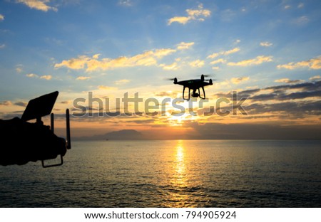 remote controlling a flying which taking photo over sunrise sea