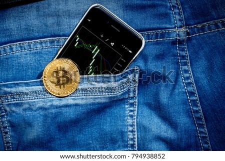 Coin bitcoin with phone on blue jeans background