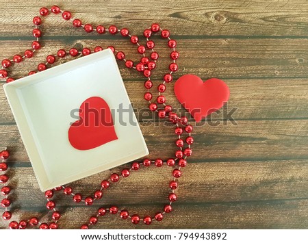 two red hearts on a wooden background, red box, romantic, beads