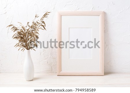 Wooden frame mockup with decorative dried grass. Empty frame mock up for presentation design. Template framing for modern art.