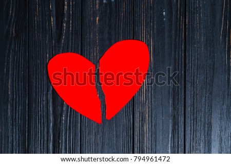 torn red heart on paper, on a dark background