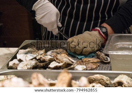 A chef is shucking an oyster Royalty-Free Stock Photo #794962855