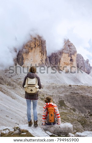 girl hiker resting and looking at the  Tre Cime di Lavaredo. Dolomites, Italy.
