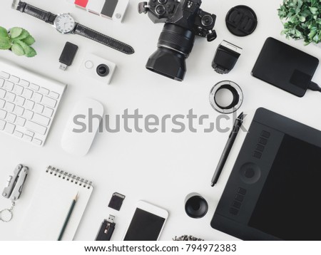 top view of photographer work station, work space concept with digital camera,pantone book, memory card, smartphone, graphic tablet, external harddisk on white background with copyspace