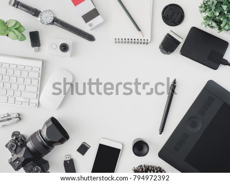 top view of photographer concept  with digital camera, memory card, smartphone, graphic tablet, external harddisk, pantone book and keyboard on white background with copy space