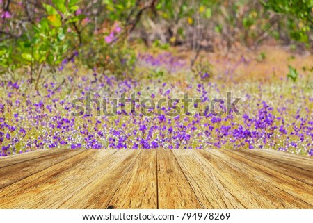 A front selective focus picture of wooden terrace house beside wild flowers