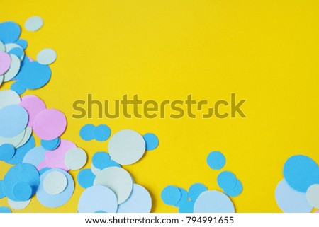 Gently blue, pink confetti on a yellow background