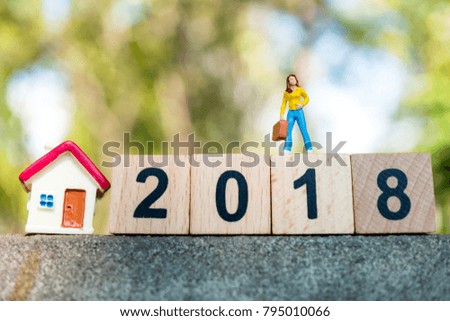 Miniature people, woman standing on year 2018 wooden block and mini house using as business and property concept