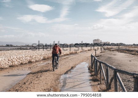 Alone aged biker along the path of Salt field - Sardinia.
