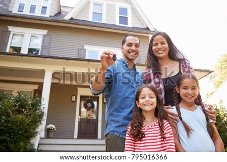 Portrait Of Family Holding Keys To New Home On Moving In Day Royalty-Free Stock Photo #795016366