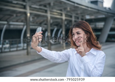 Portraits of Pretty Beautiful Asian woman taking a photo by selfie in urban.