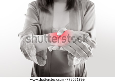Asian woman holding her hand against gray background , Pain concept
