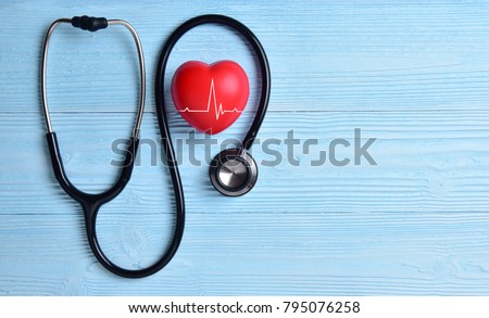 Red heart with heartbeat or heart rate and stethoscope on blue wooden background. Copy space. Medical and Health care, Valentines day.