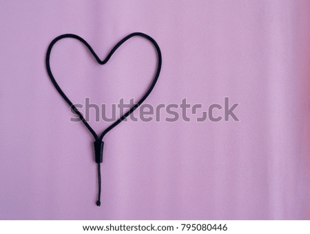 Heart made of rope on pink background of valentine day.