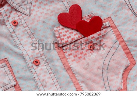 two hearts on the background of a pink shirt pocket. close-up.Valentines Day background consept.