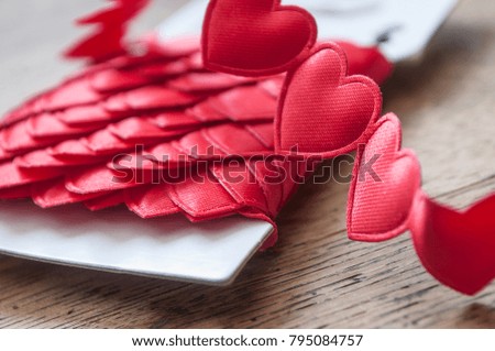 closeup of shaped heart ribbon on wooden background 
