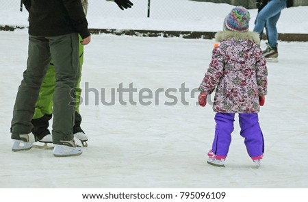 parents teach a little girl to skate