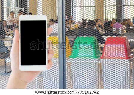 woman use mobile phone and the three colors of the bin for the waste seperation in the canteen of university