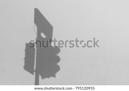 shadow of a traffic light pole on white concrete wall