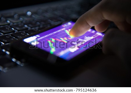 Hand man and Stock market chart of Stock Exchange Board data on desktop and mobile screen.
