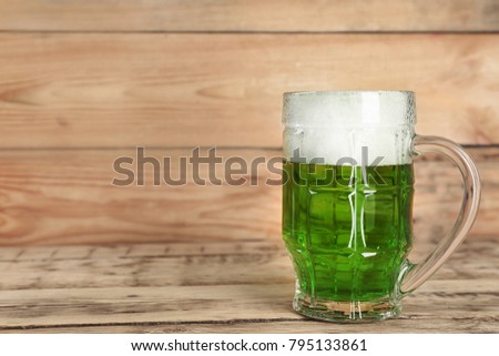 Glass of green beer on wooden background. Saint Patrick's day celebration