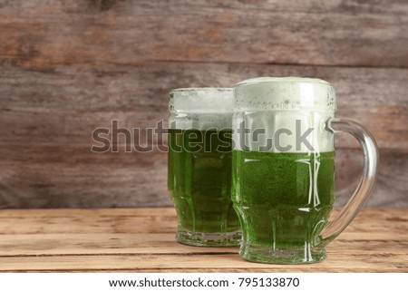 Glasses of green beer on wooden background. Saint Patrick's day celebration