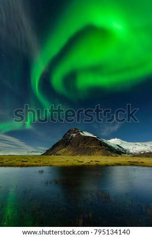 Northern light in Iceland an amazing paradise. Spectacular aurora borealis near the glacier lagoon Jokulsarlon. Beautiful nightscape. Royalty-Free Stock Photo #795134140
