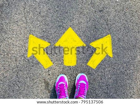 Female pink sport shoe with yellow drawn direction  arrow as guidance, top view. Young street lifestyle, which way your choice Royalty-Free Stock Photo #795137506