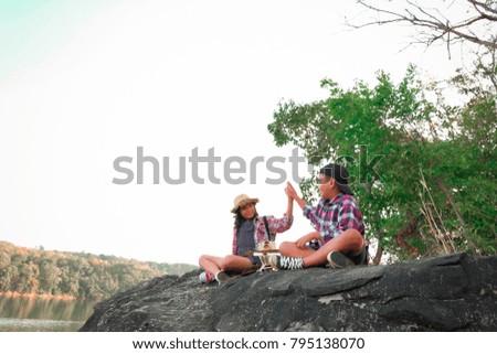 Two kids hiking with backpacks walking studying the route map in a sunny summer day on a forest, Relax time on holiday concept travel, Thailand.