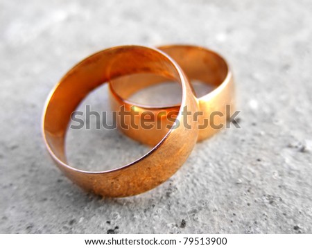 Two gold wedding rings on a stone