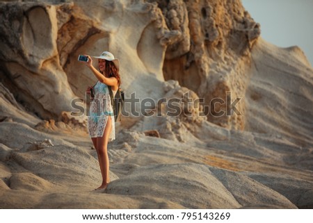 Young woman taking a photo at the beach
