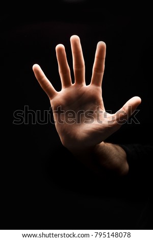 Male hand making stop sign with hand palm isolated on black background, copy space, cutout