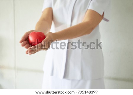 Woman take care a red heart to healthy by hospital.