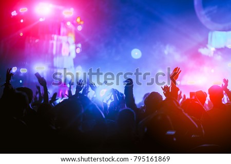 silhouettes of hand in concert.Light from the stage. Royalty-Free Stock Photo #795161869