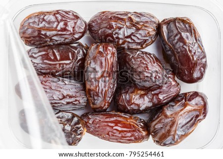 Directly above shot of Medjool dates in a plastic container on white background