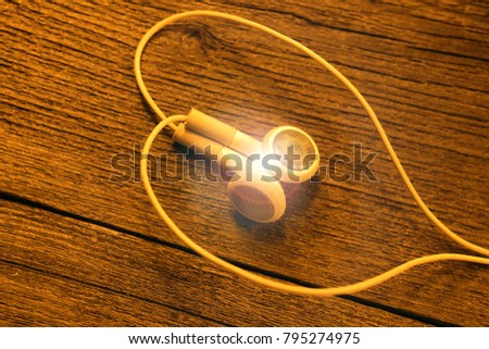 headphones folded in the form of a heart symbol. on a wooden board