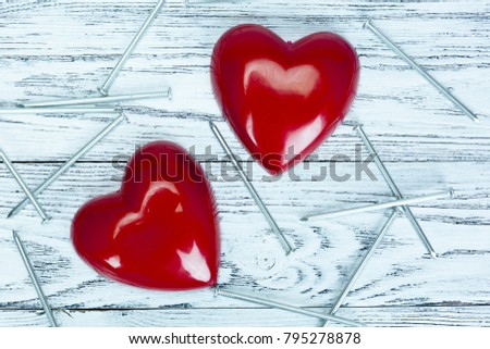 Two halves of a heart and nails on a white wooden background