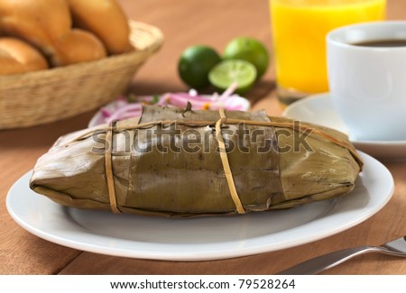 Peruvian food called Tamal which is prepared from cooked corn mixed with chicken and wrapped in banana leaves. It is eaten for breakfast or as appetizer at lunch (Selective Focus, Focus on the front) Royalty-Free Stock Photo #79528264