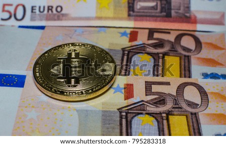  A virtual bitcoin coins versus euro banknotes.