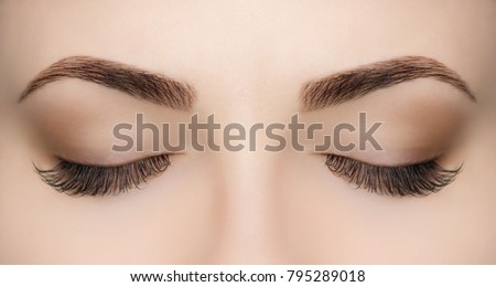 Beautiful Woman with long lashes in a beauty salon. Eyelash extension procedure.  Royalty-Free Stock Photo #795289018