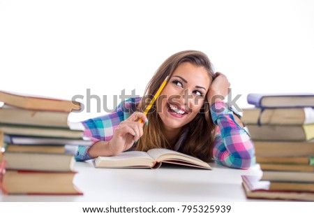 Happy student reading and thinking between book holding a pencil