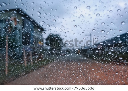 Abstract image of Rain drops on the dirty glass windows with building background

