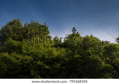 man standing on top of the hill taking photo with camera against clear blue sky