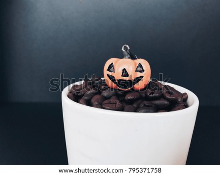 Halloween style concept, Halloween pumpkin, pine cones with coffee beans on black background. happy halloween on decorative pumpkins for background