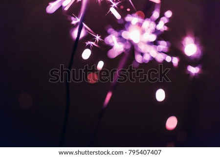 lilac Bengal  sparkler lights on a black background in honor of Christmas and New Year and birthday celebrations