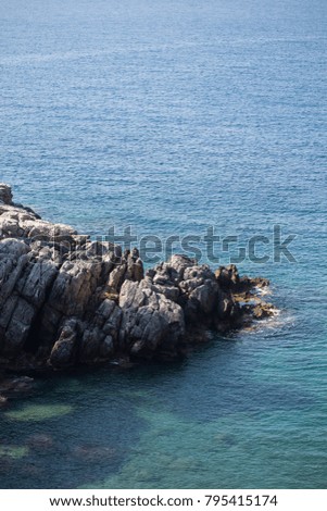 Seascape with rocks in the turquoise pristine water. Vertical composition. Copy space.