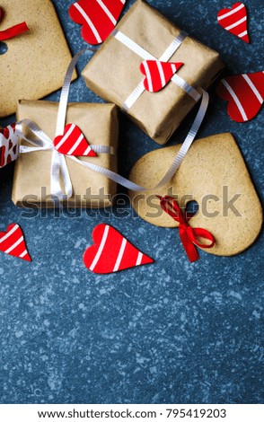 Gift box with decorative red hearts and heart shaped cookies. Festive background. Flat lay with copy space.