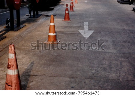 Walkway in front of the building and orange rubber cones. Put the rubber cones to say that do not parking.