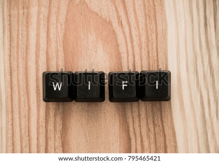 Letters on button of keyboard form a word - wi fi or wifi on wooden table background