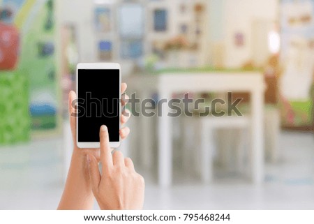 woman use mobile phone and blurred image of children classroom